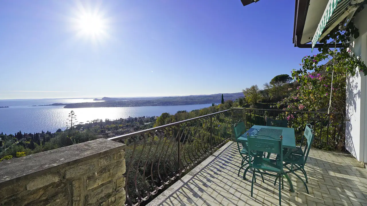 Terrasse mit Tisch und Stühlen mit Blick auf den See und die Landschaft