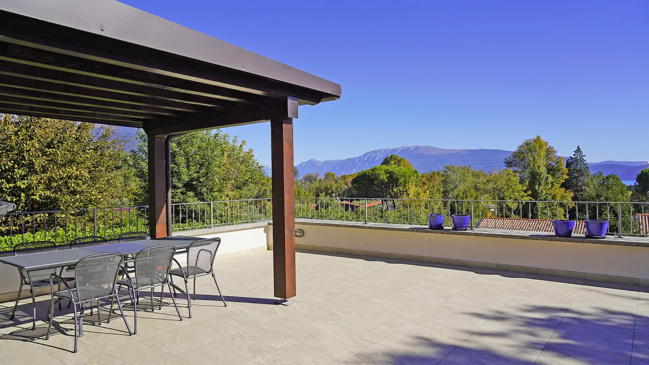 Terrasse mit Tisch und Stühlen unter Holzpergola