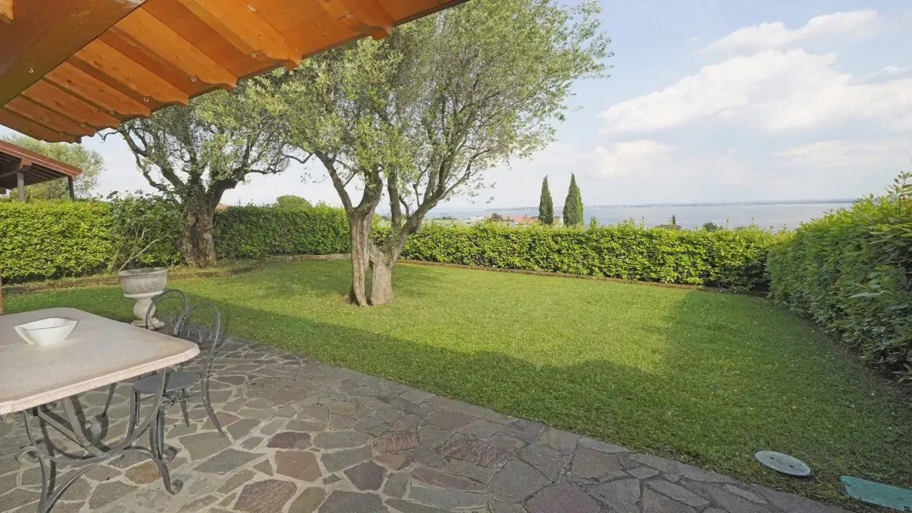 Giardino con prato, alberi e vista lago