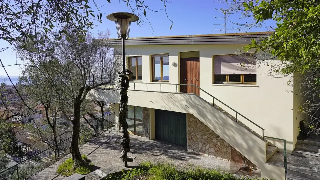 Villa facade with external stairs and partial lake view