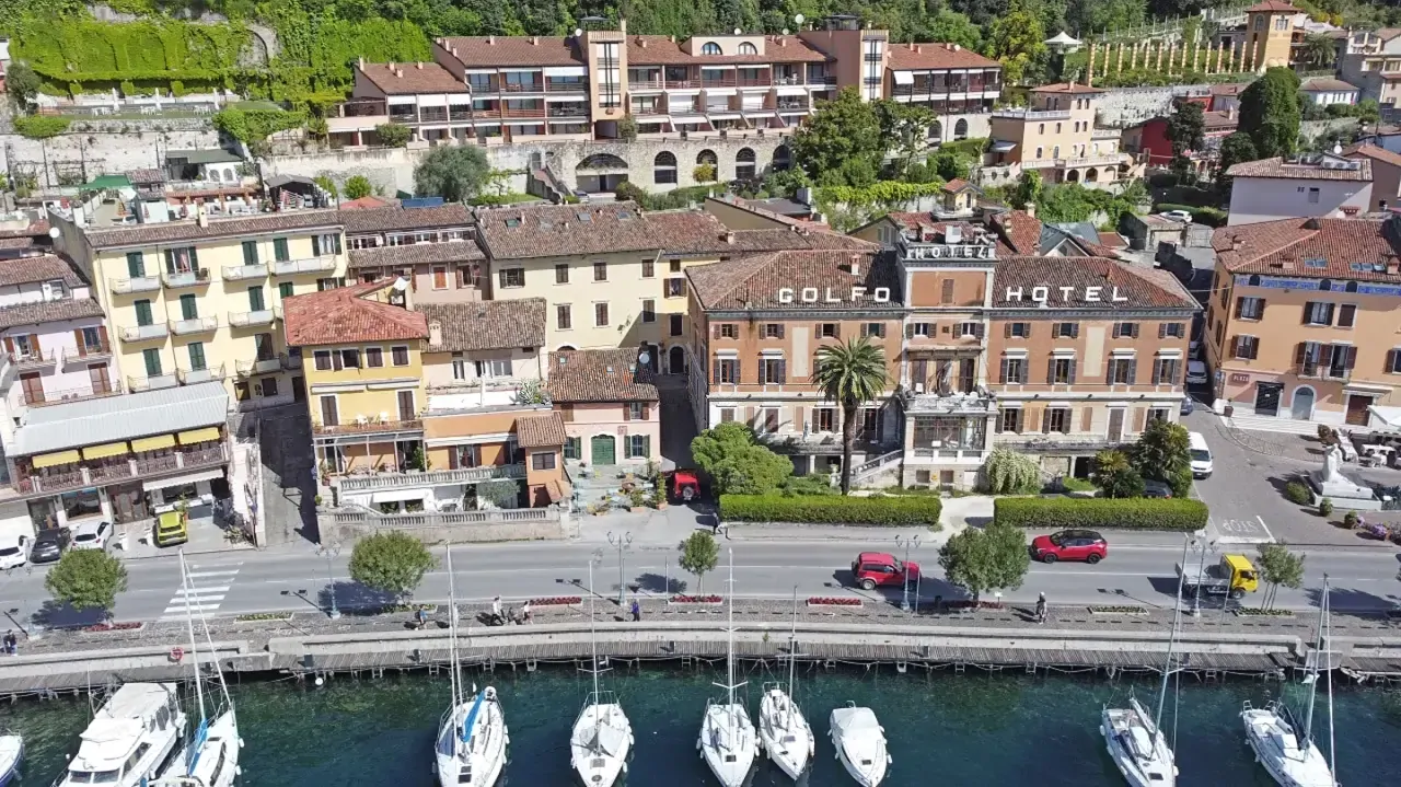 Veduta aerea del lungolago con barche ormeggiate e edifici storici