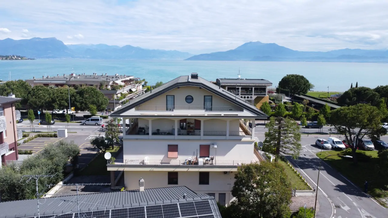 Three-level building with lake view and surrounding parking