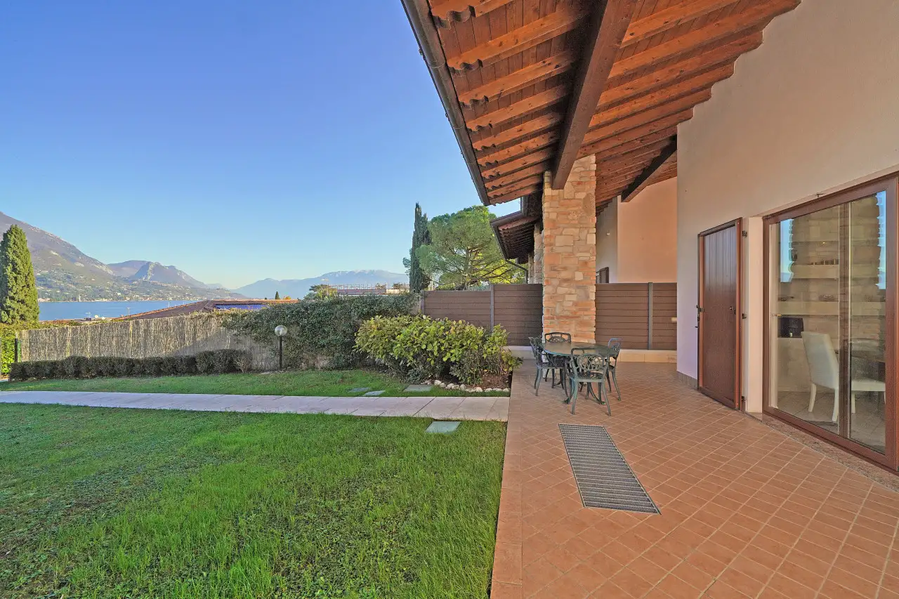 Veranda mit Tisch und Stühlen mit Blick auf Garten und See