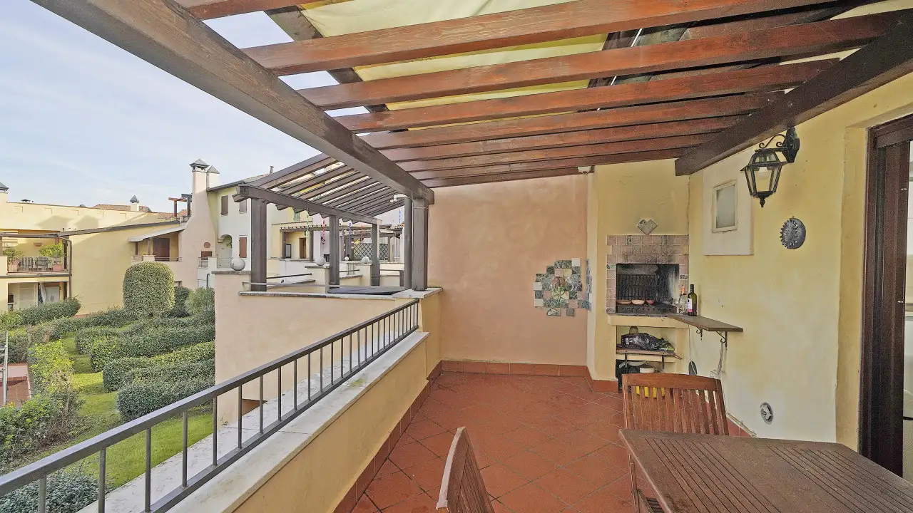 Covered terrace with barbecue and wooden table