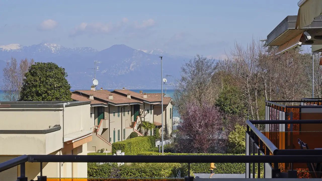 View from balcony with houses and lake in the background