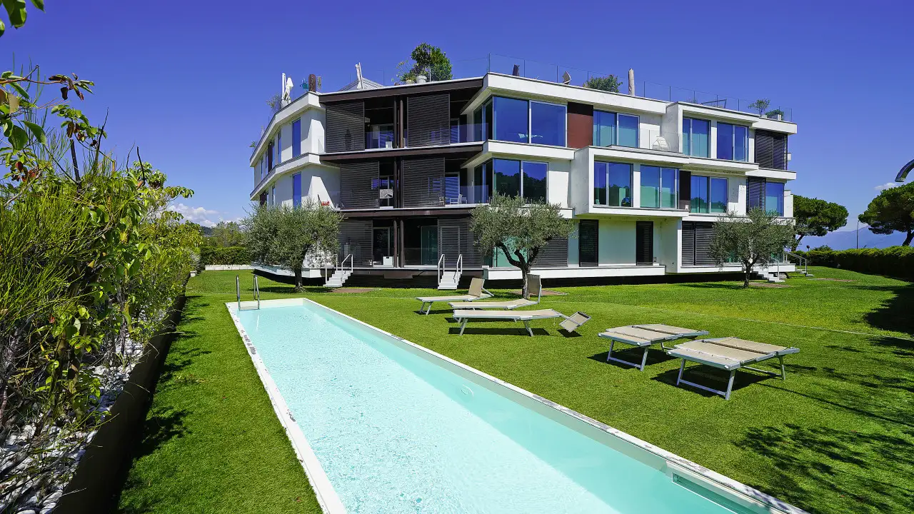 Esterno con piscina e prato verde davanti a edificio moderno