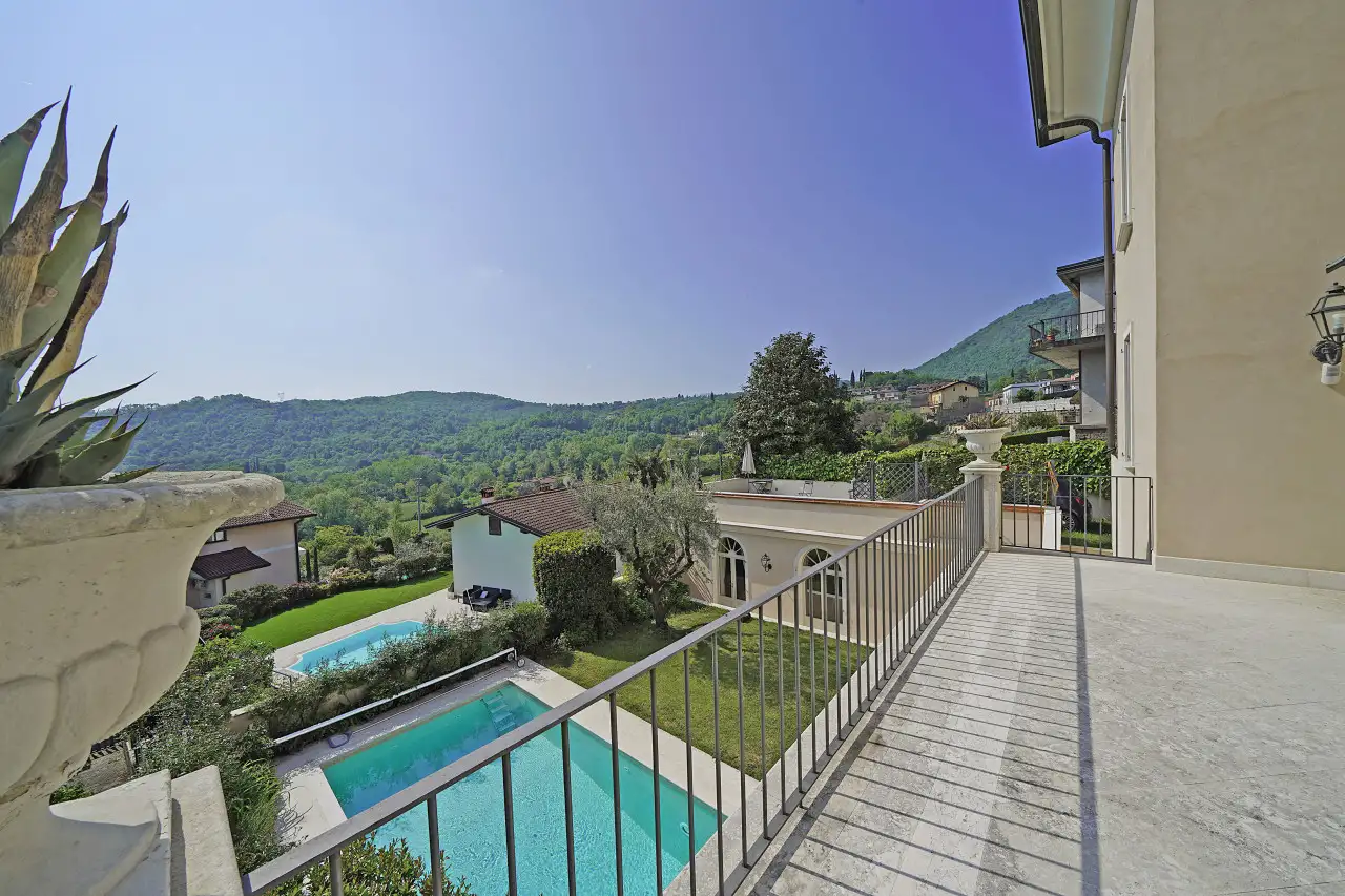 Terrazza con ringhiera e vista su piscina e giardino