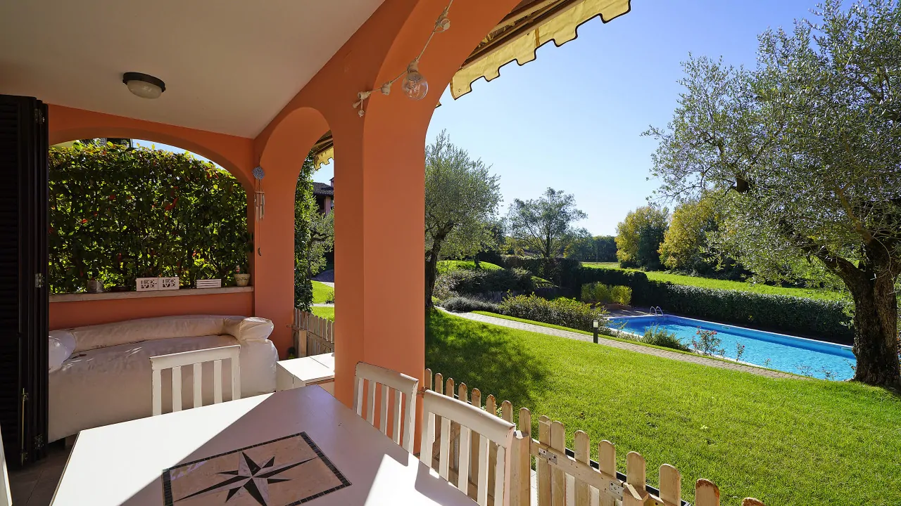 Terrazza con tavolo e vista sulla piscina e giardino