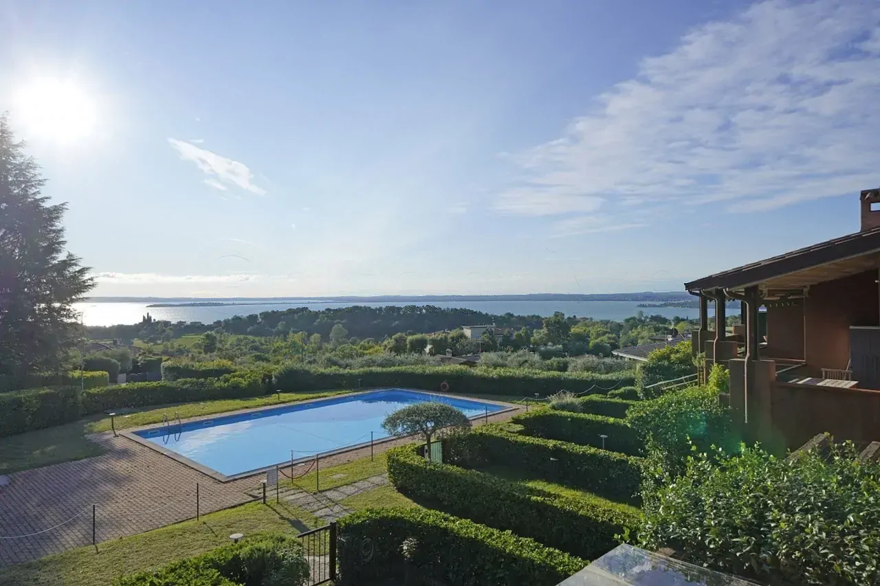 Außenpool mit Seeblick und umliegendem Garten