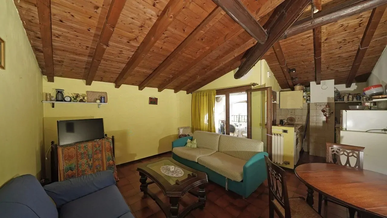 Wohnzimmer mit Sofas, Couchtisch und Holzdeckenbalken