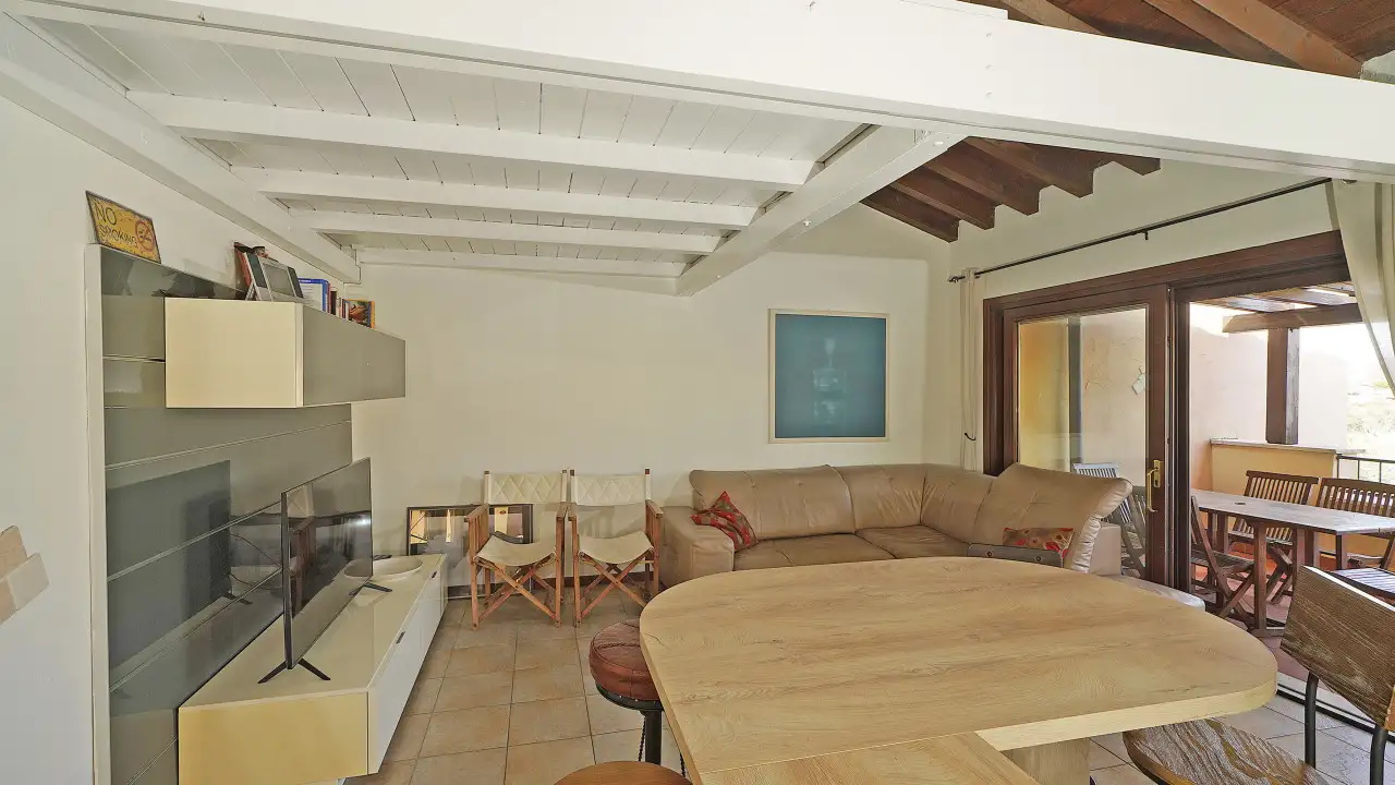 Living room with corner sofa and wooden table near the glass door