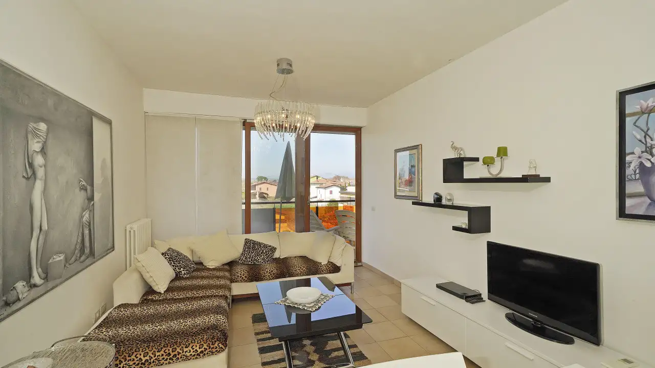 Living room with corner sofa and glass door to balcony