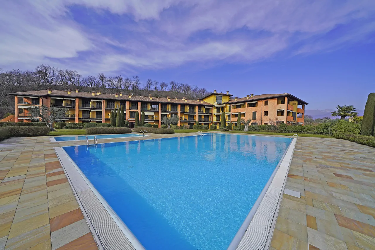 Rectangular swimming pool in residence with building in the background