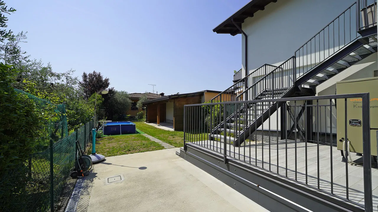 Exterior with metal staircase and garden with above-ground pool