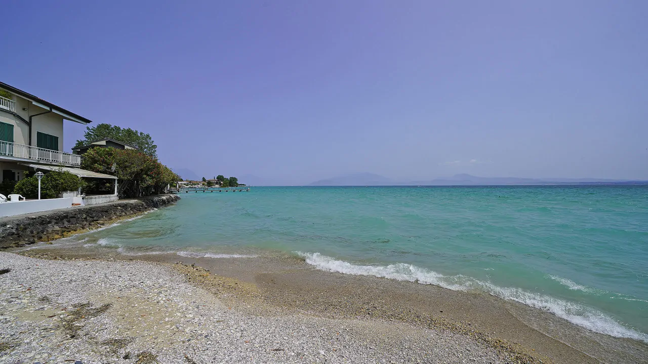 Spiaggia con acqua turchese e edificio a sinistra