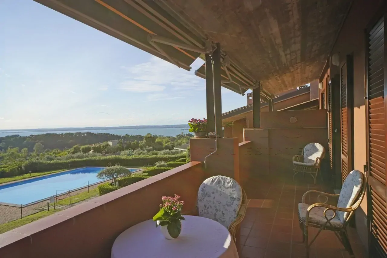 Terrace with table, chairs and view of pool and lake