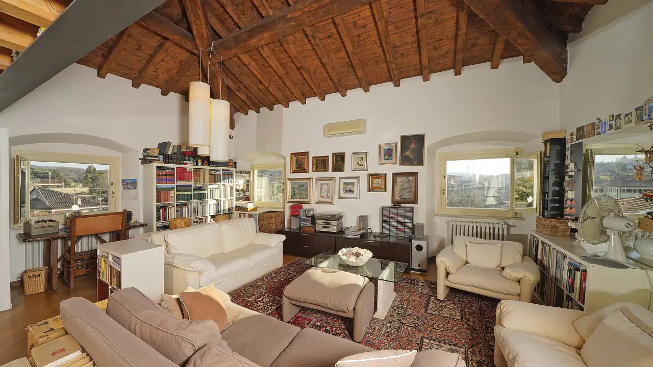 Living room with exposed beams and light sofas