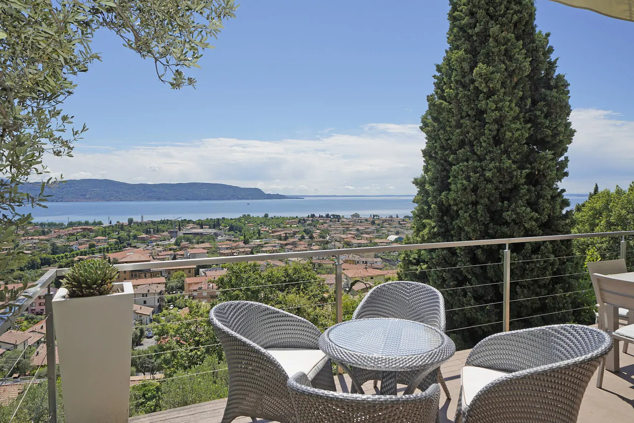 Terrazza con tavolo e sedie in vimini e vista lago