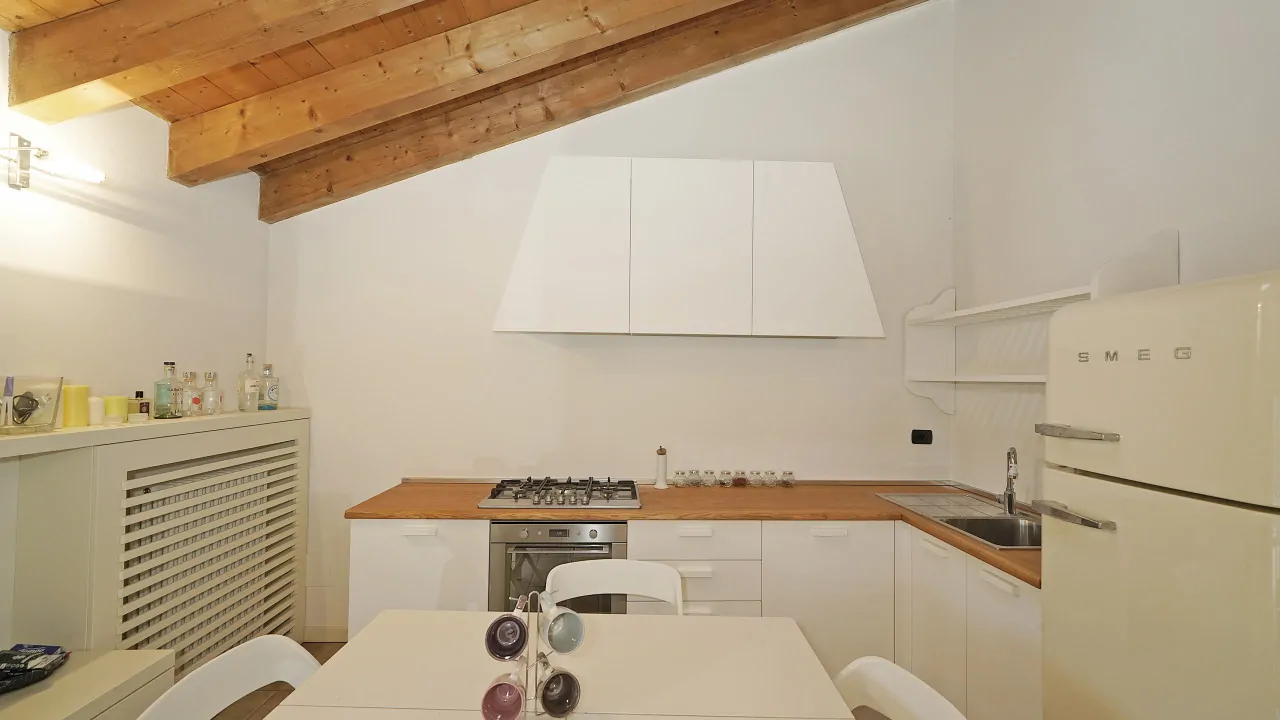 Küche mit sichtbaren Holzbalken und SMEG-Kühlschrank