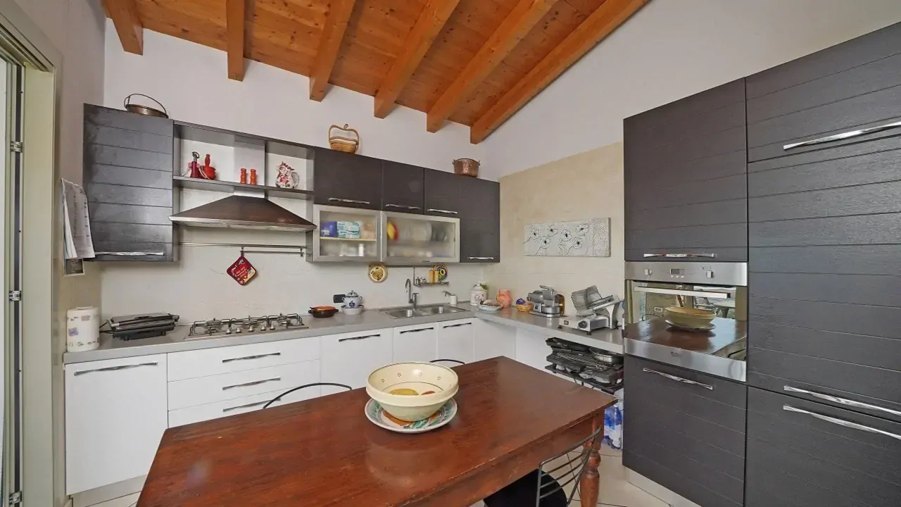 Küche mit Holzdecke und weißen und schwarzen Schränken