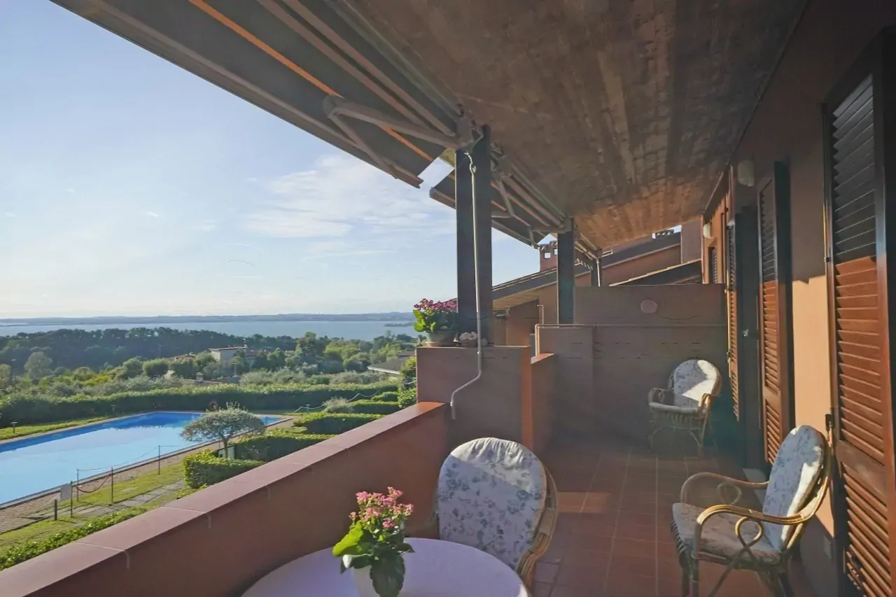 Terrace with table, chairs and view of lake and pool