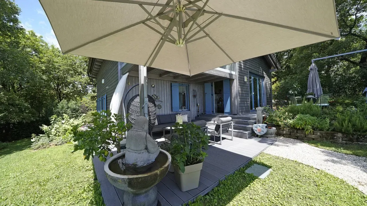 Außenterrasse mit Sonnenschirm und Gartenbrunnen