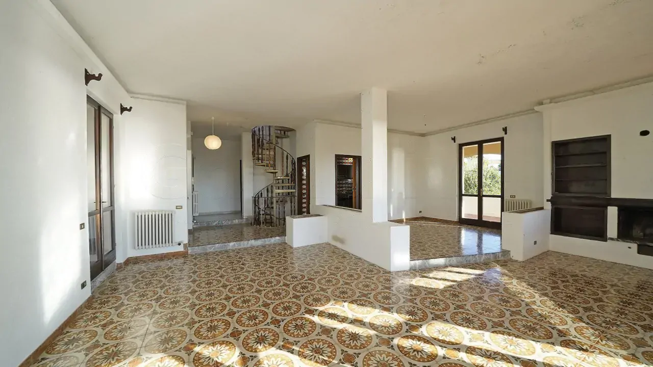 Large living room with decorated tile floor and fireplace