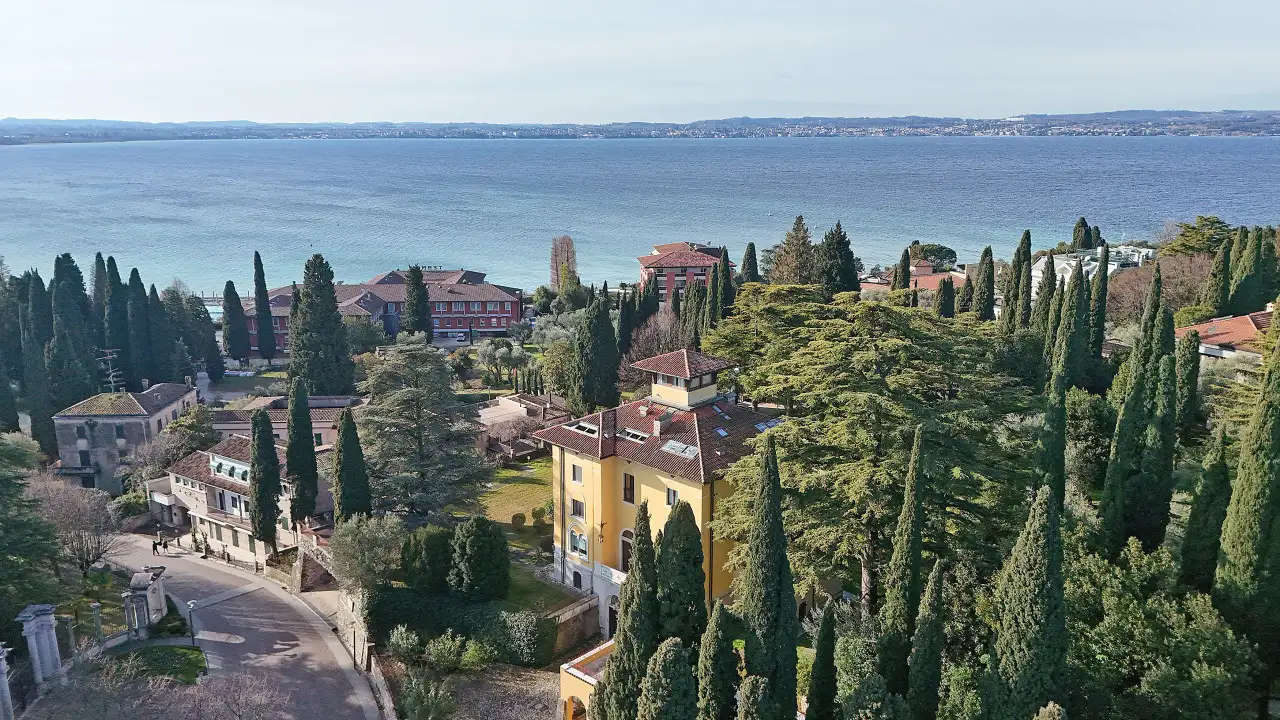 Veduta aerea del lago e delle abitazioni con alberi alti a Sirmione