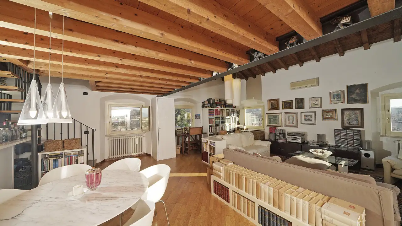 Living room with exposed wooden beams and bookshelf behind sofa