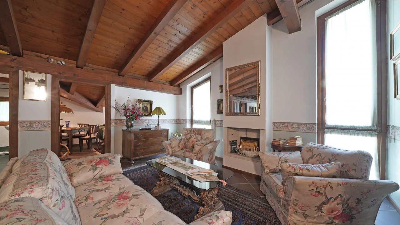 Wohnzimmer mit sichtbaren Holzbalken und Kamin