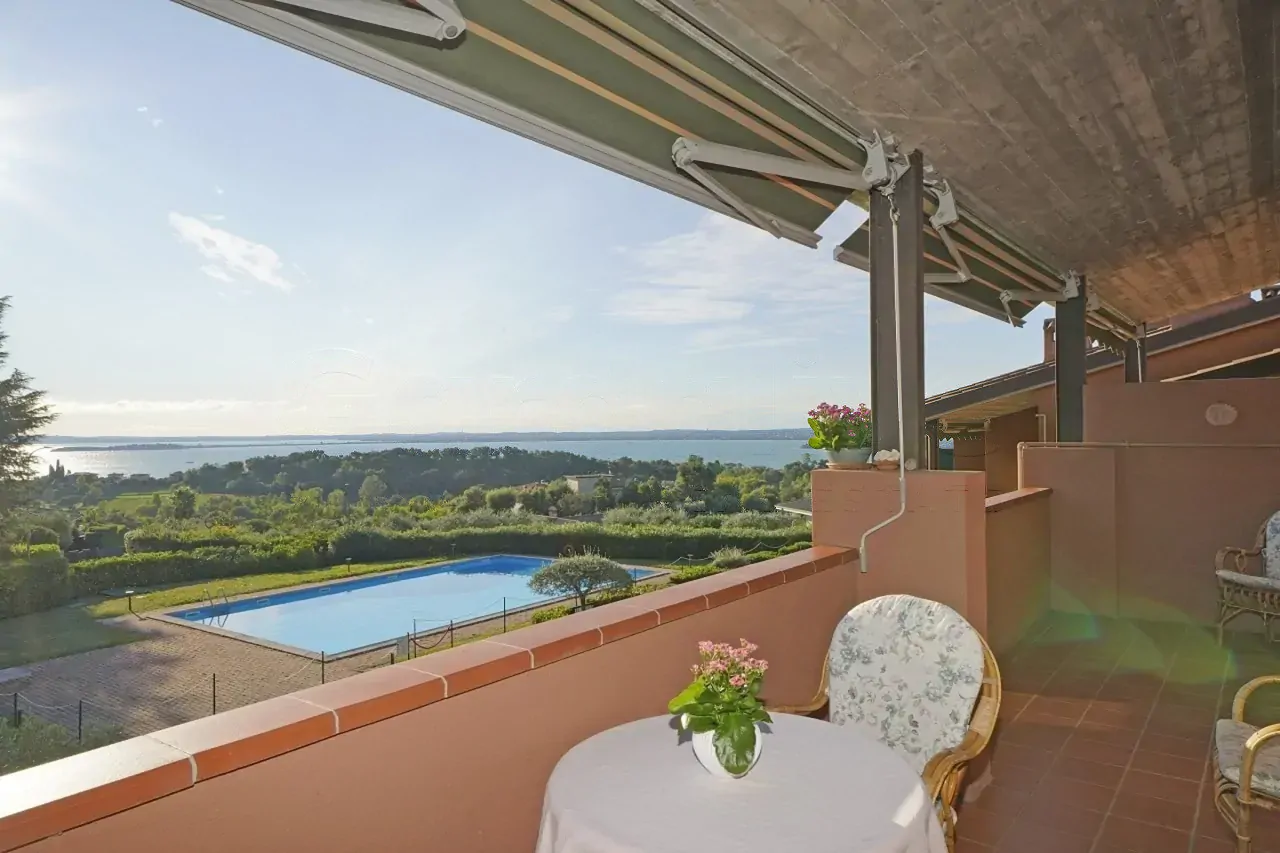 Terrace with table, chairs and view of pool and lake