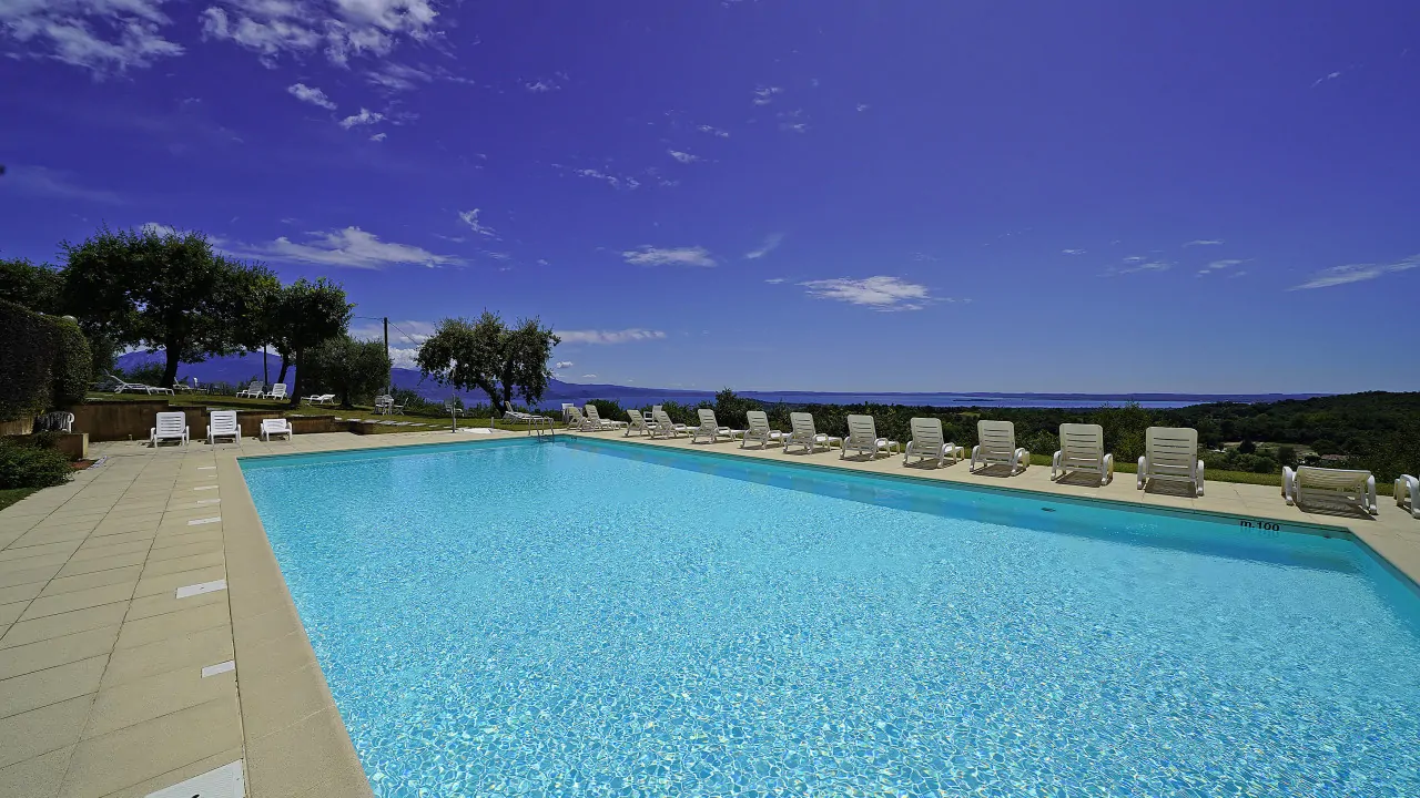 Piscina all'aperto con sdraio e cielo sereno