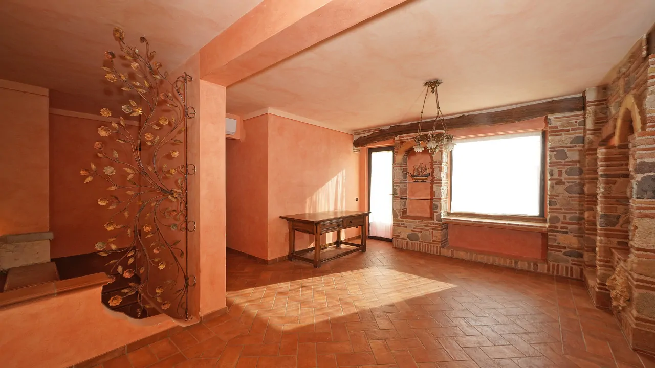 Wohnzimmer mit orangen Wänden und Steinkamin