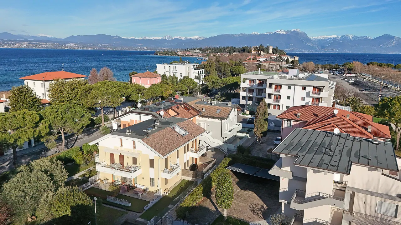 Vista aerea di edifici residenziali con lago e montagne sullo sfondo