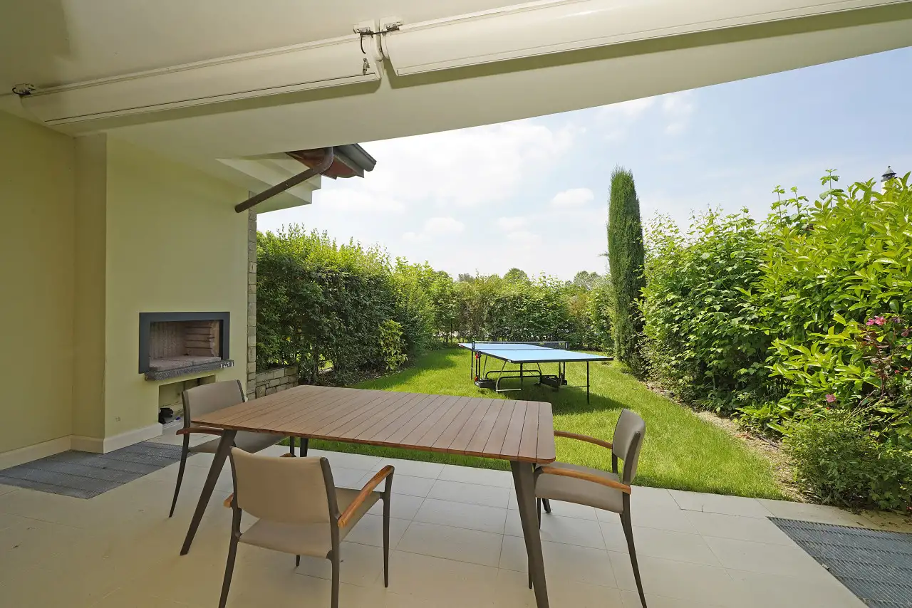 Garten mit Tischtennisplatte und überdachtem Essbereich mit Außenkamin