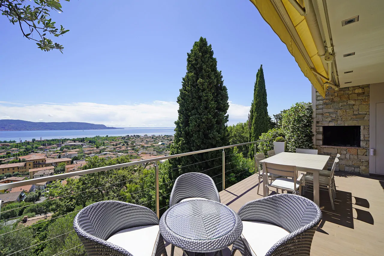 Terrazza con tavolo e sedie e vista sul lago e paesaggio