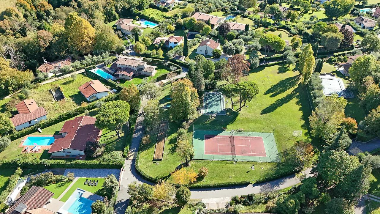 Luftaufnahme eines Wohngebiets mit Tennisplätzen und Schwimmbädern