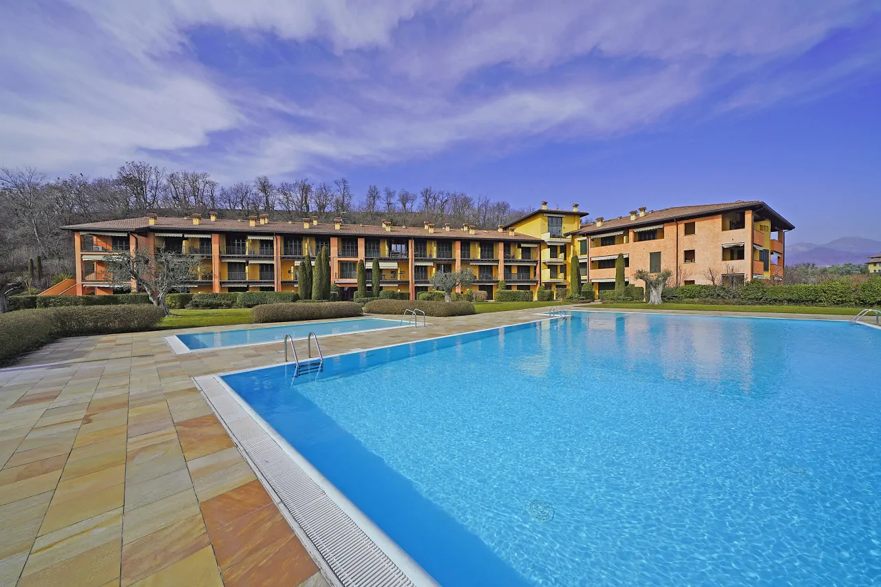 Piscina esterna con edificio residenziale sullo sfondo