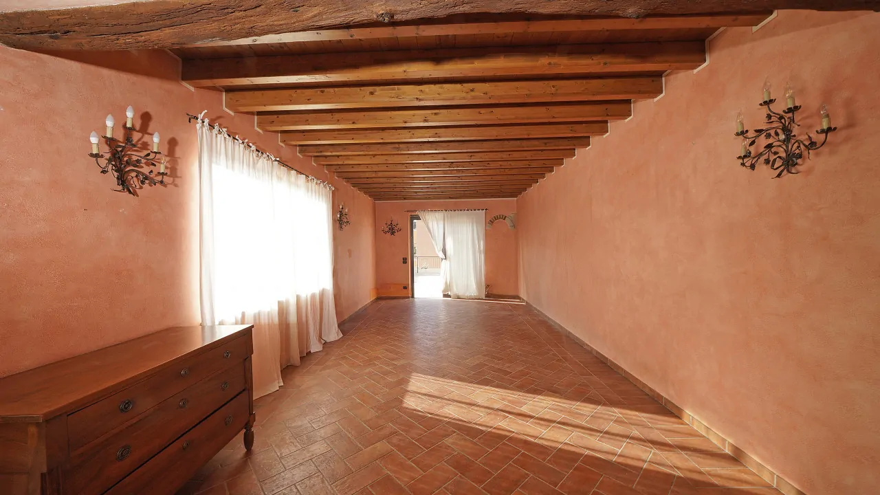 Wohnzimmer mit sichtbaren Balken und Terrakottaboden