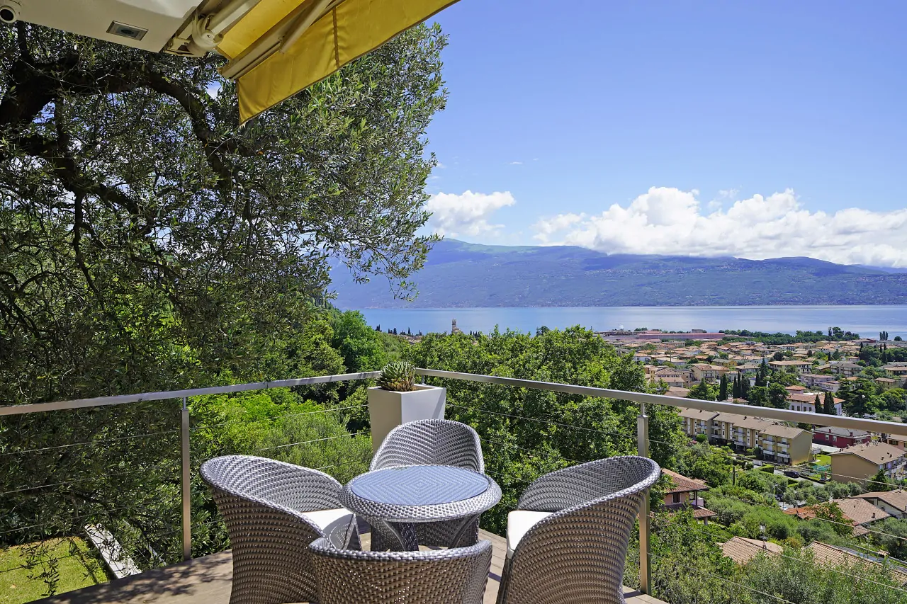 Terrace with rattan table and chairs overlooking the lake and hills
