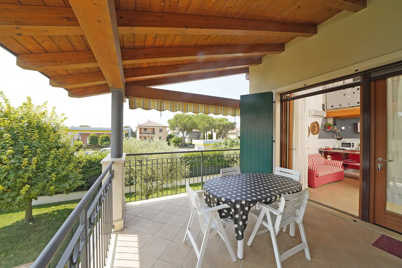 Covered terrace with round table and white chairs