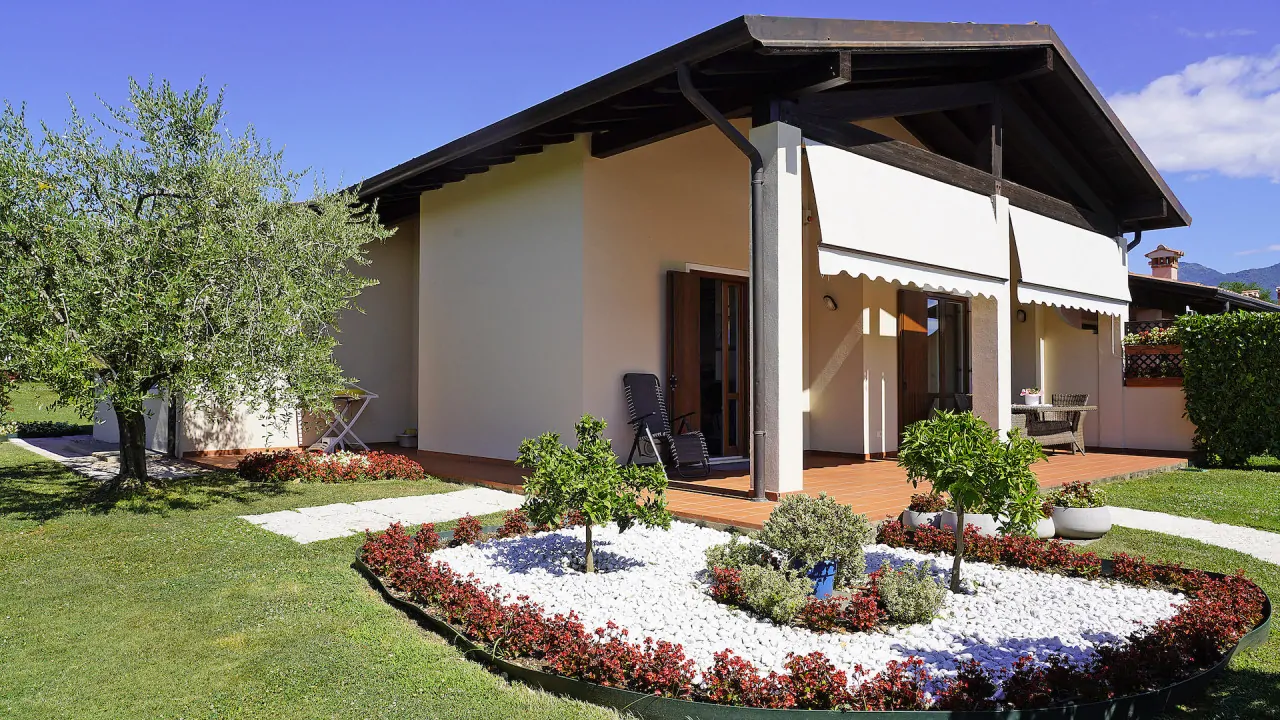 Villa con portico e giardino curato con aiuola fiorita
