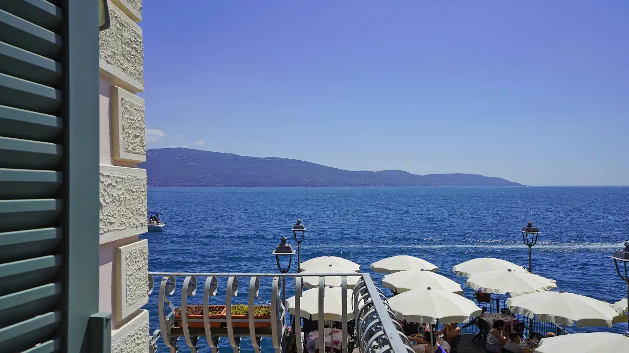 View of the lake with white umbrellas and railing in the foreground