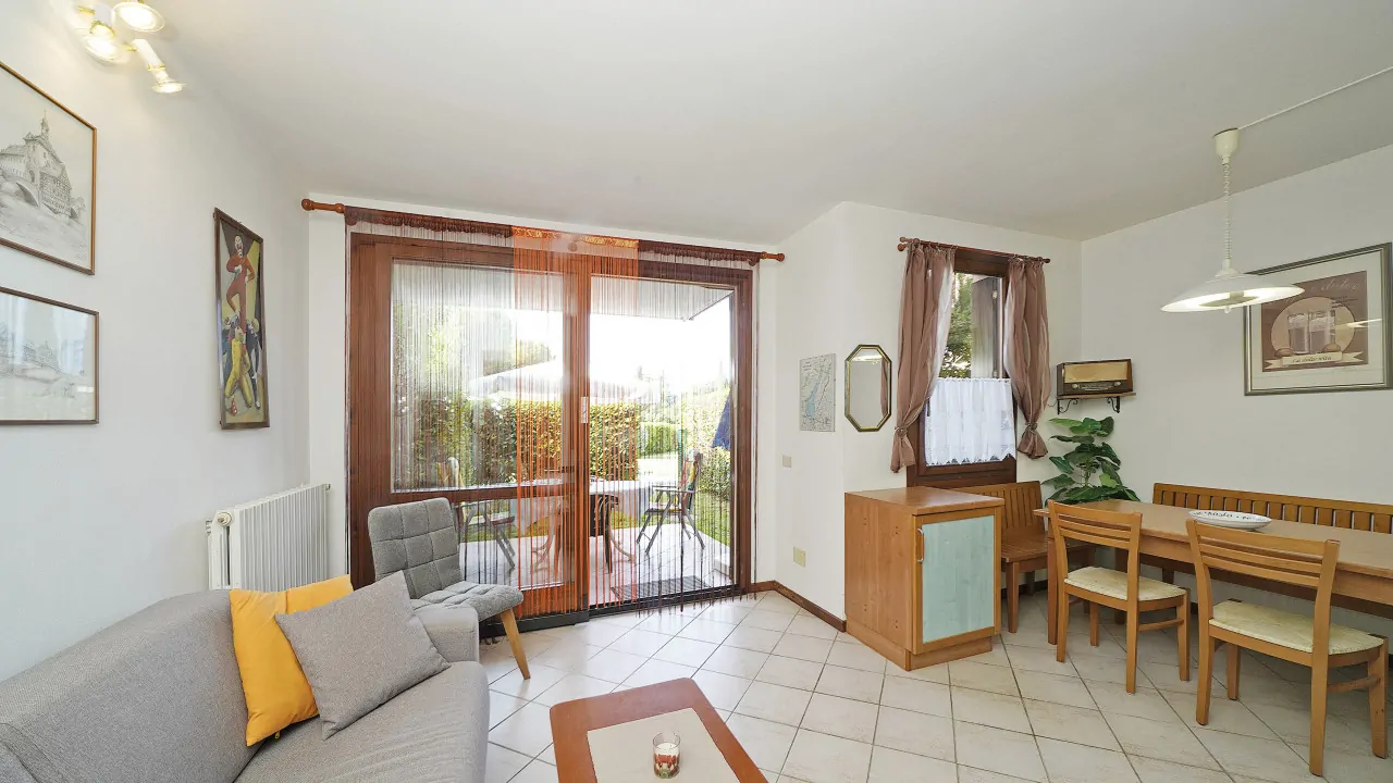 Wohnzimmer mit Sofa und Glastür zum Garten