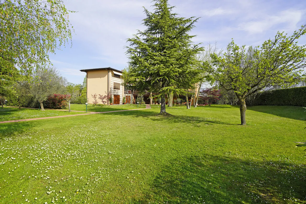 Garden with trees and green lawn in front of residential building