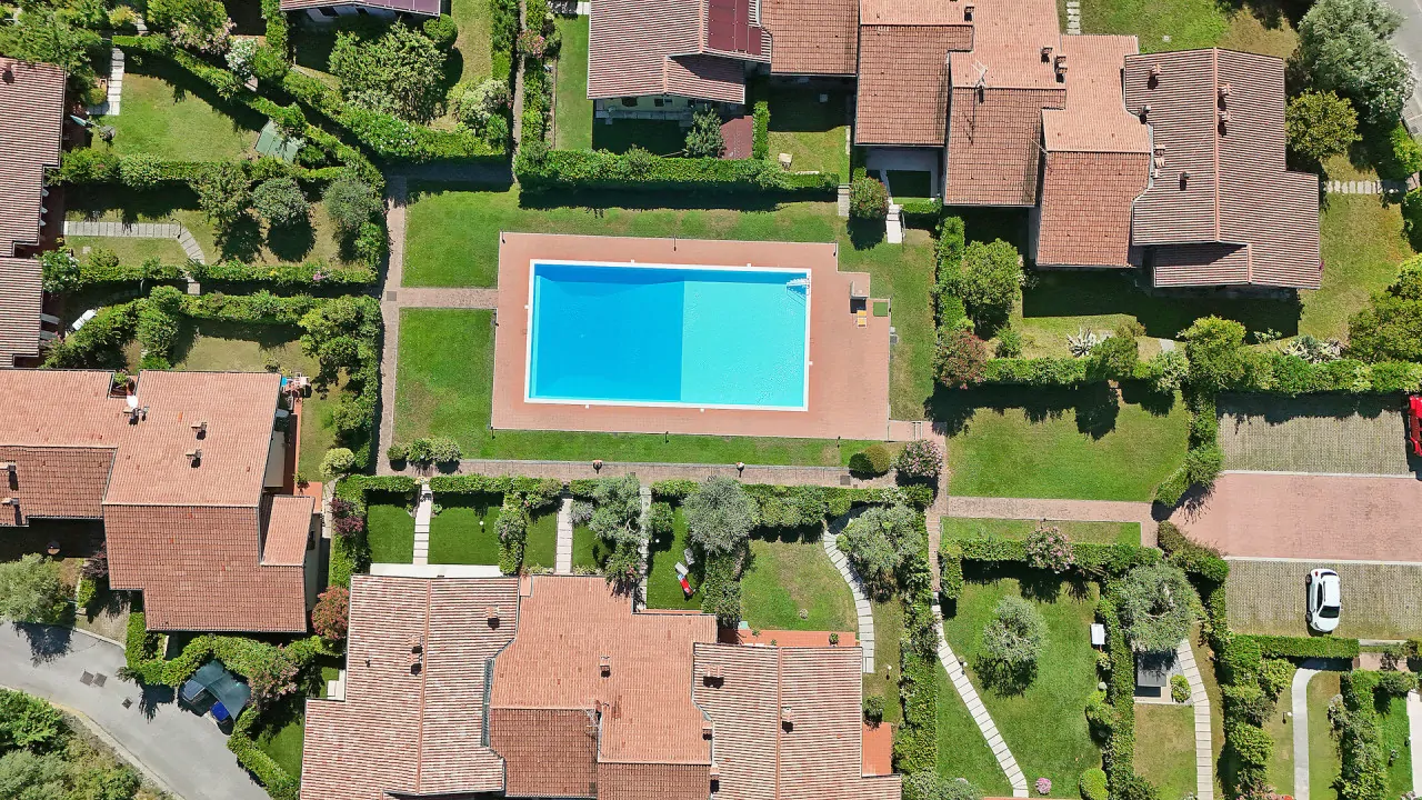 Rechteckiger Pool in Wohnanlage mit Rasen und Wegen