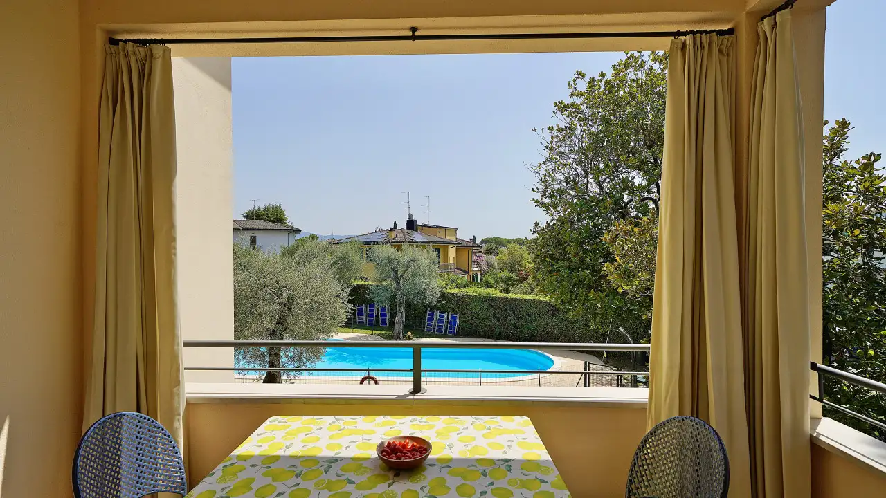 Terrace with table and view of the pool and garden