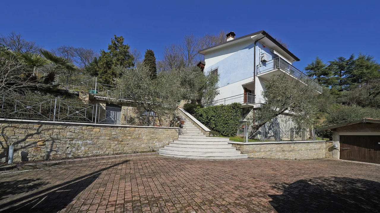 Freistehende Villa mit Außentreppe und Steinmauer