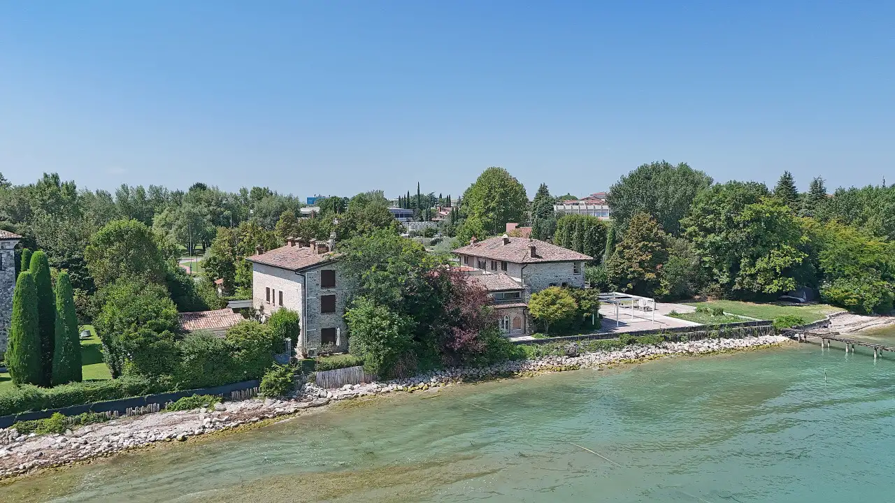 Vista aerea della villa storica fronte lago con giardino e alberi a Sirmione