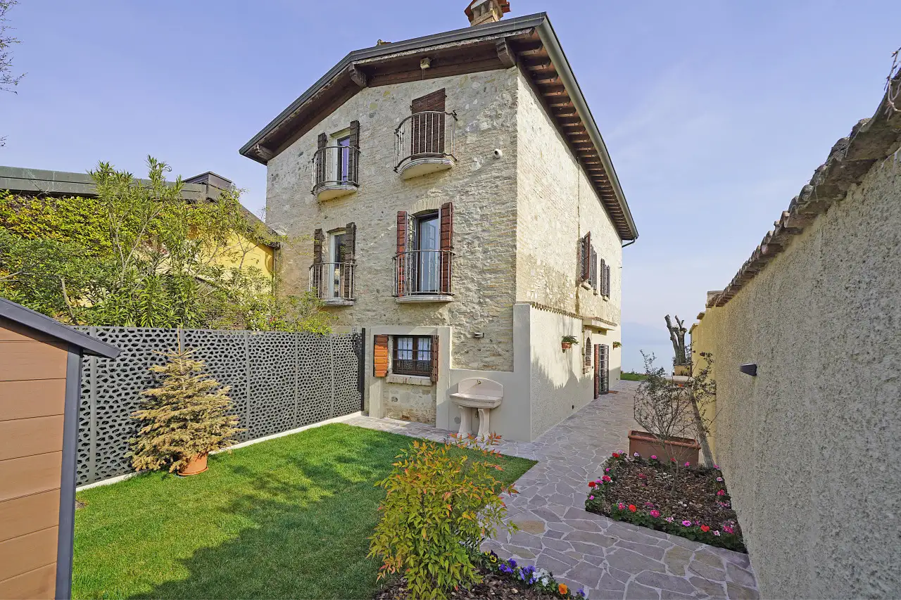 Facciata di villa storica con giardino e vialetto in pietra